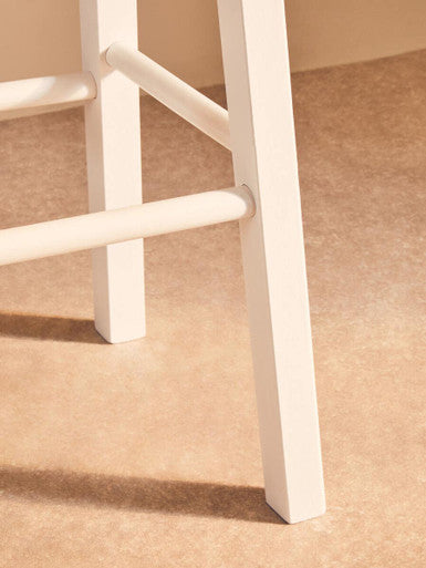 Close-up of Orsina Bar Stool featuring sturdy white wooden legs for modern bar seating