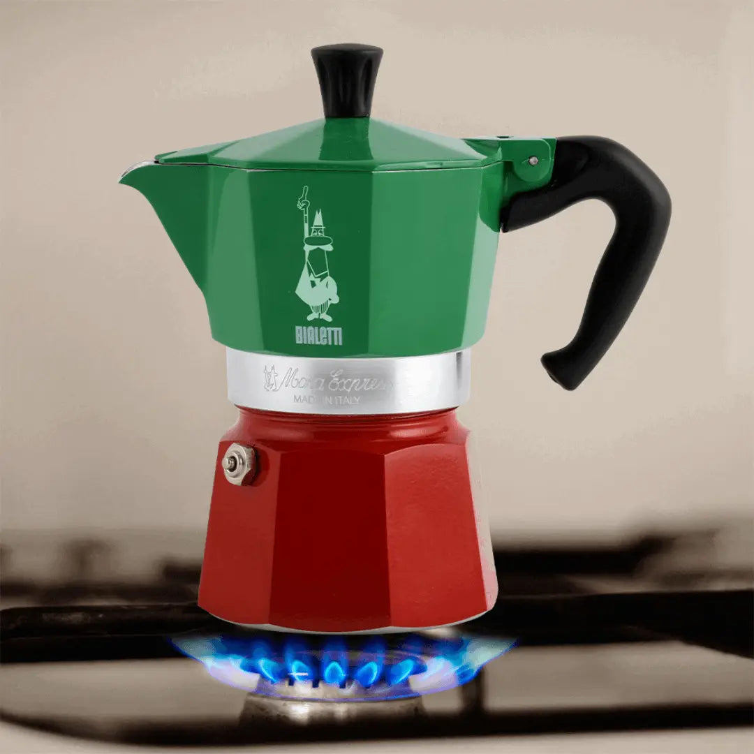 Bialetti Coffee Maker in green and red on a gas stove, brewing fresh coffee