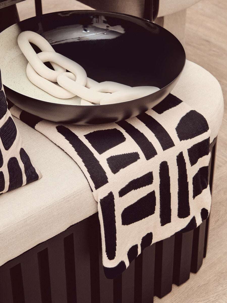 Orsina Black Throw with Geometric Design Draped Over a Beige Sofa for Modern Interiors