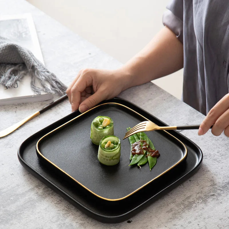 Elegant Blino Plates by Nisu Home featuring a black design and gold trim, perfect for stylish dining