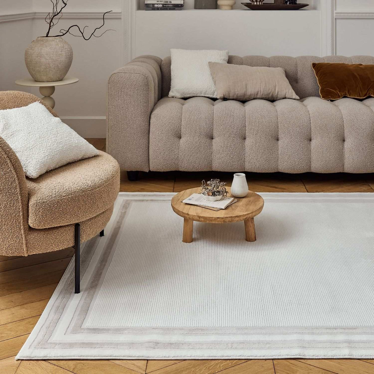 Stylish bordered rug in a modern living room with a beige sofa and decorative cushions