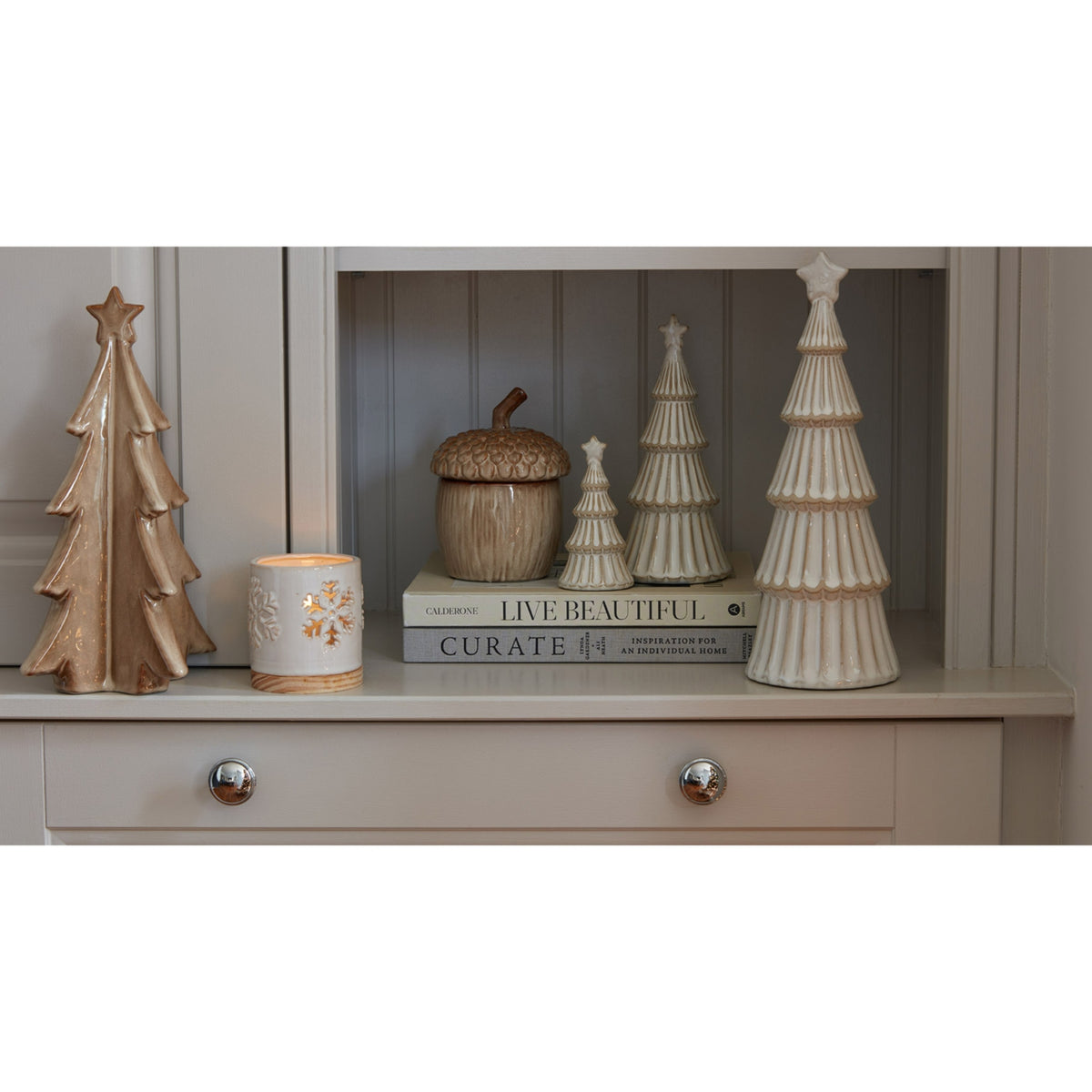 Elegant ceramic candle holders and decorative Christmas trees in a festive home setting