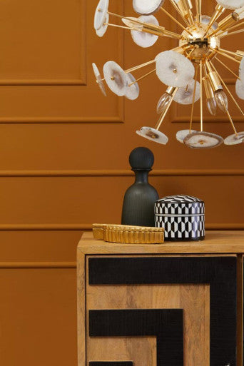 Stylish Orsina Ceiling Light with a unique design and decorative elements against an orange wall