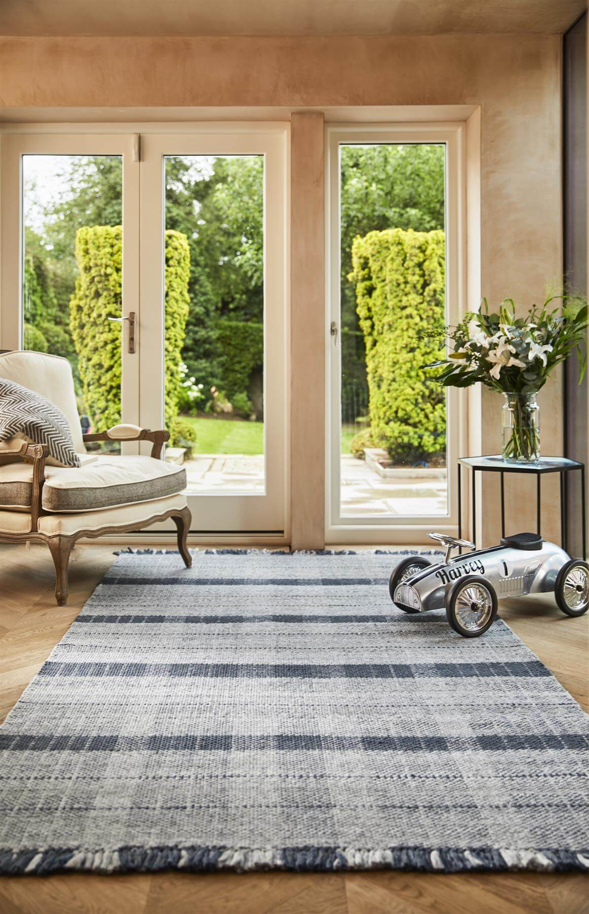 Stylish checkered rug in blue tones enhancing a bright living room with large windows