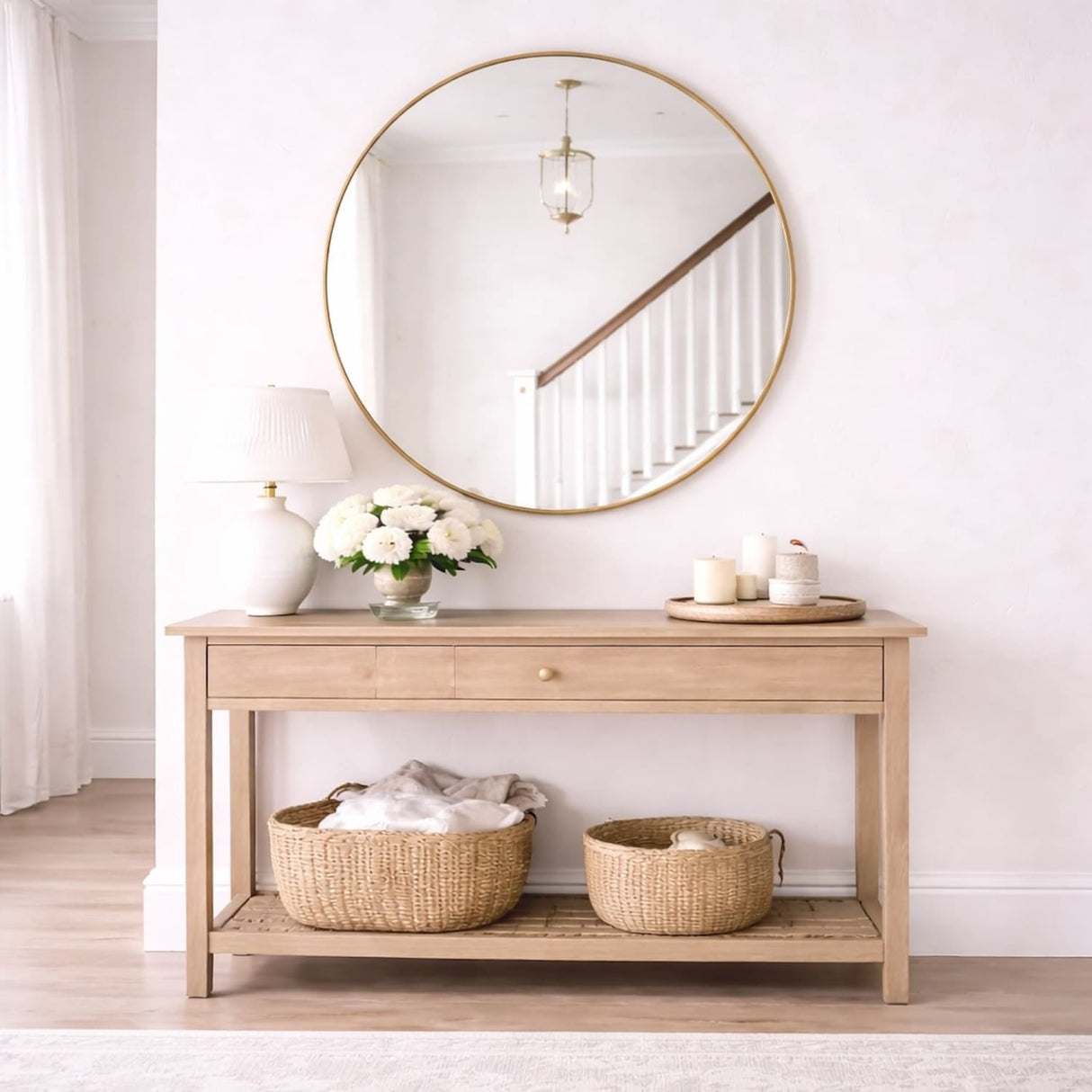 Elegant Circle Mirror above a wooden console table with decorative baskets and a vase of flowers