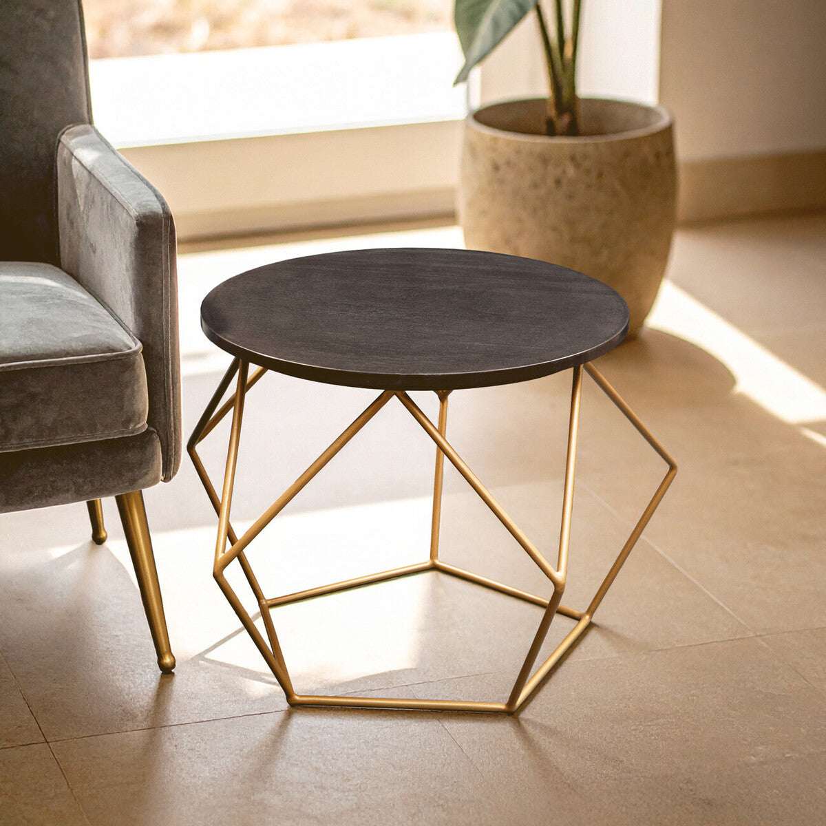 Modern Orsina Coffee Table with a round black top and geometric gold base for stylish living spaces