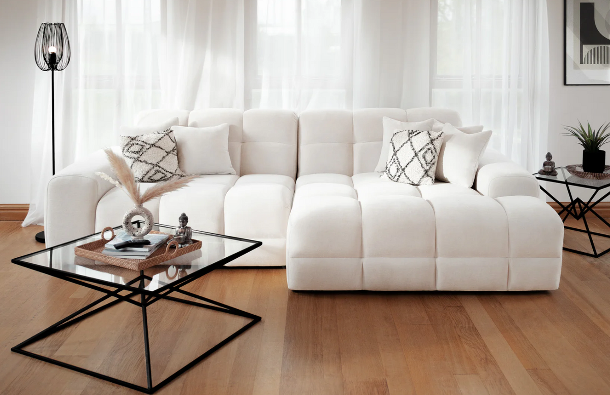 Elegant corner sofa in plush white fabric with decorative cushions for stylish living spaces