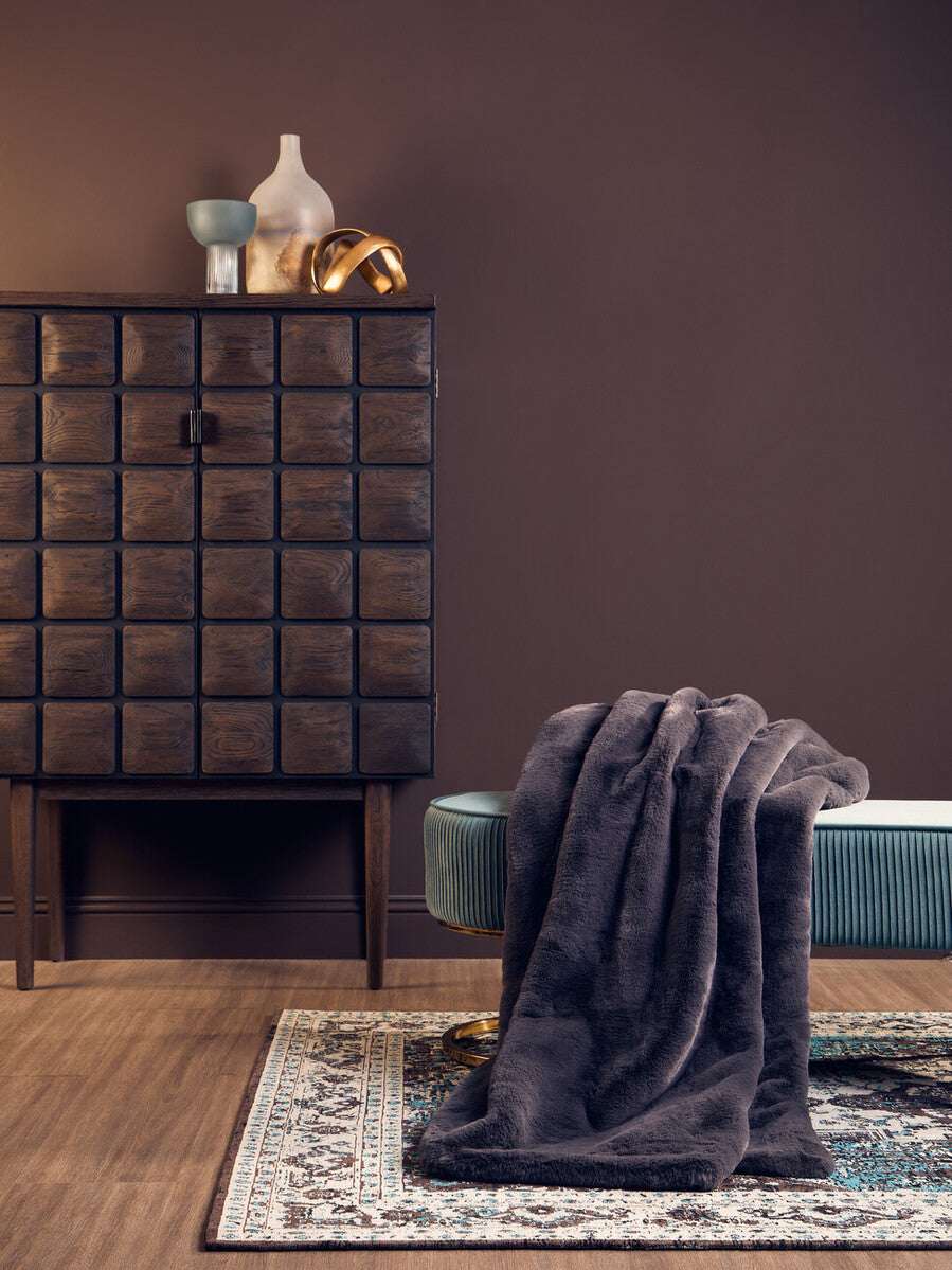 Orsina Fur Throw draped over a stylish bench in a modern interior setting