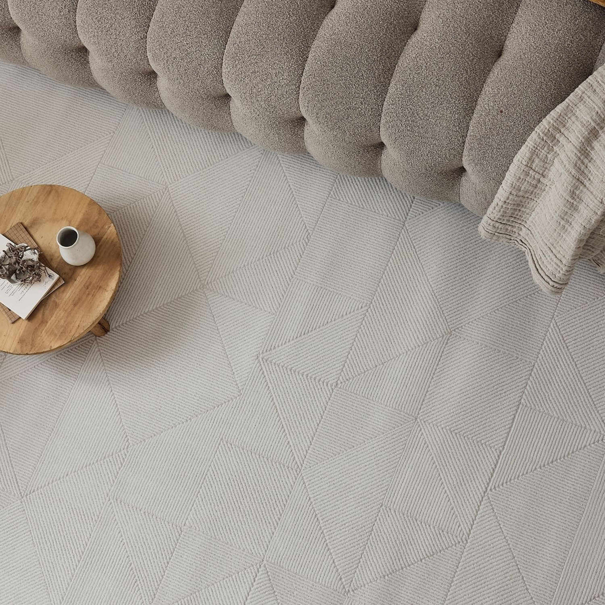 Stylish cream rug with a geometric pattern, complementing the plush sofa and wooden coffee table