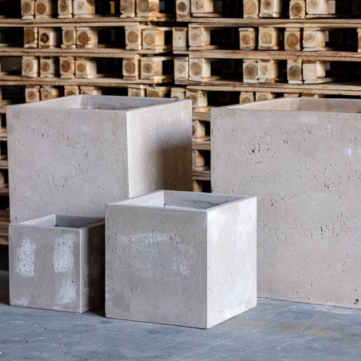 Four modern grey Cube Planters in various sizes for stylish indoor or outdoor planting