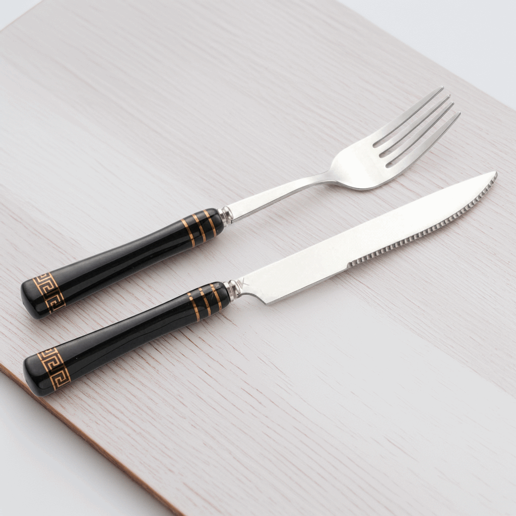 Elegant KitchBoom Cutlery Set featuring black handles with gold detailing and stainless steel utensils