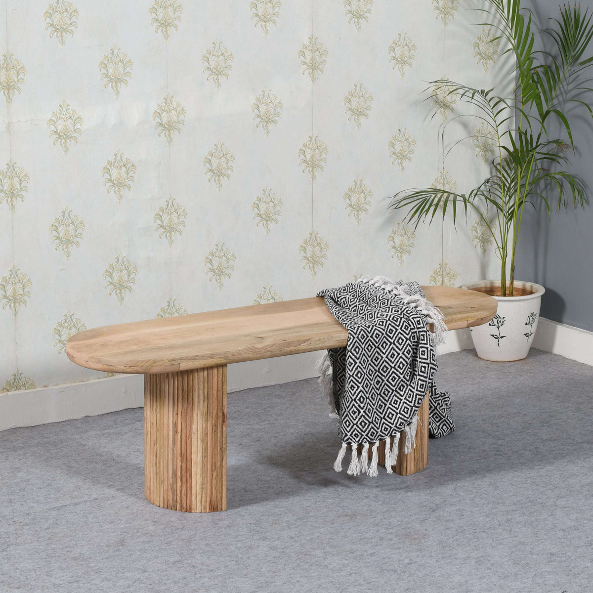 Verty Furniture Dining Bench in natural wood finish with soft blanket and decorative plant