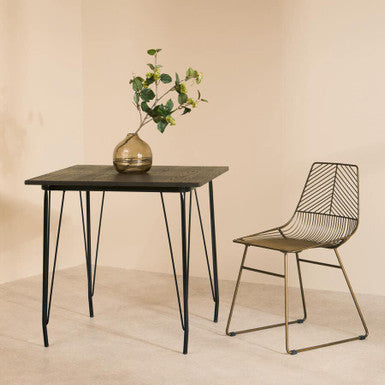 Orsina Dining Table with Elegant Design and Black Metal Legs, Surrounded by a Stylish Chair