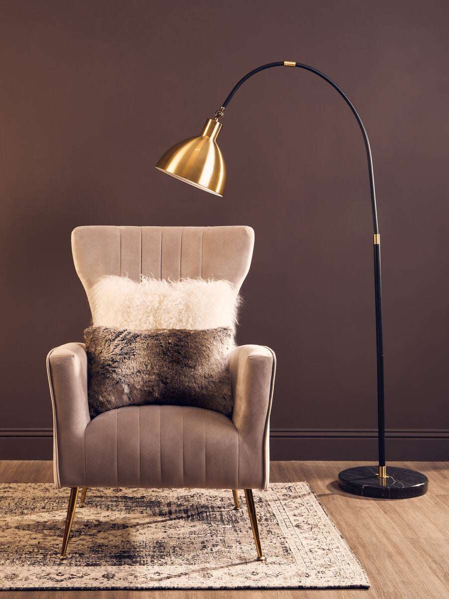 Orsina Fur Cushion on a stylish armchair with a floor lamp in a modern living room setting