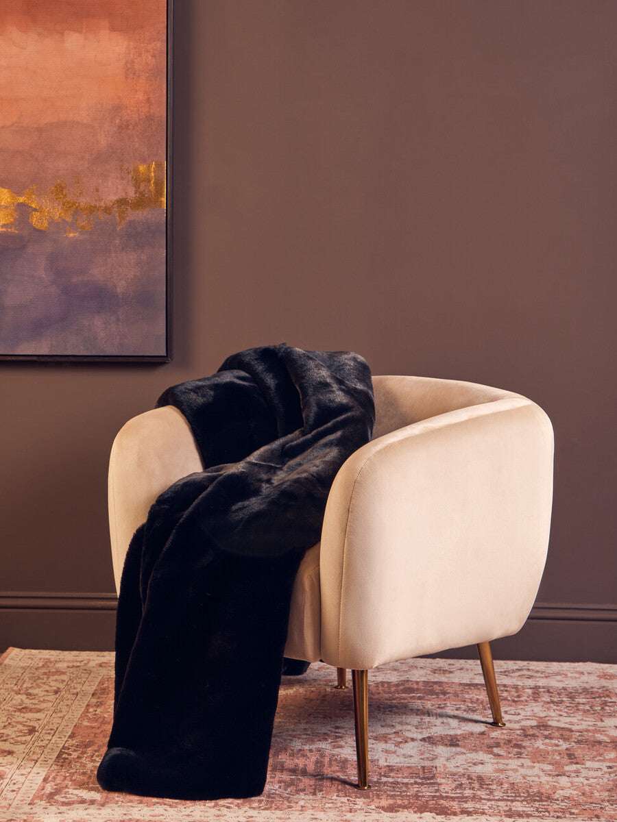 Orsina Black Fur Throw Draped Over a Stylish Cream Armchair in a Modern Living Room