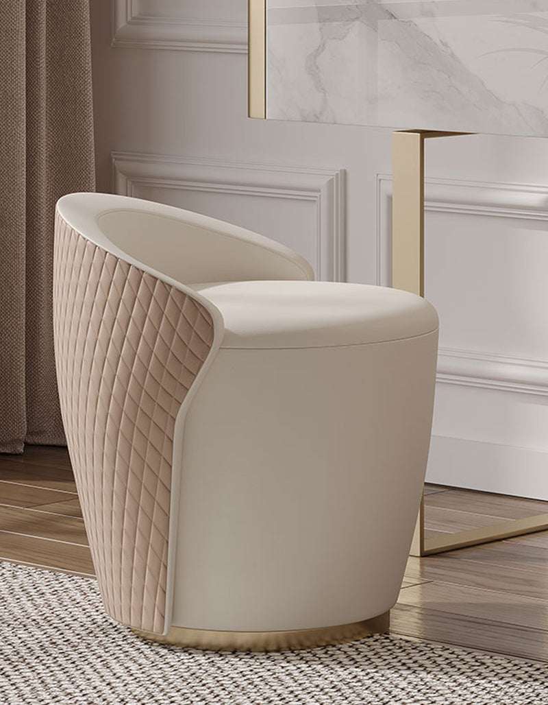 Elegant cream upholstered chair with quilted design beside a stylish dressing table