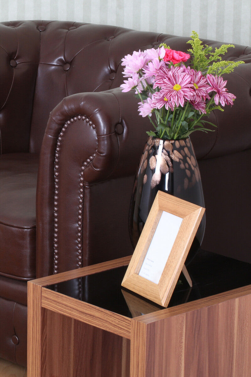 Stylish Nest of Tables from Orsina beside a brown leather sofa with a vase of flowers