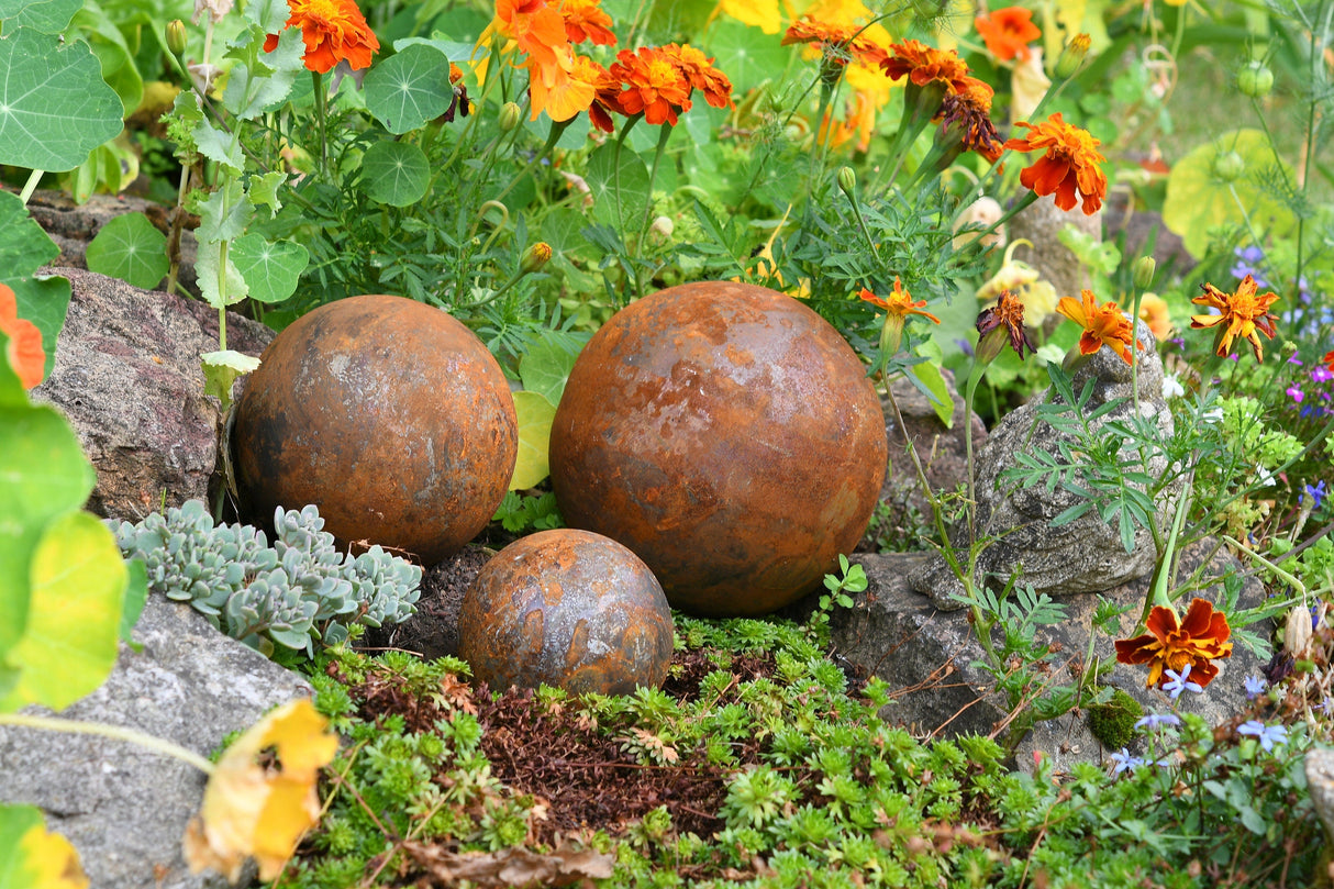 Rusty Garden Metal Balls in a Lush Flower Bed Perfect for Outdoor Decor