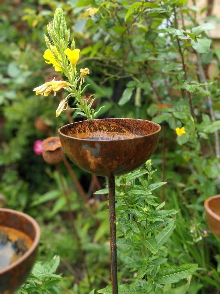 Rustic Rain Catcher Garden Feature with a Natural Finish and Yellow Flowers in Background
