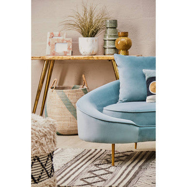 Orsina Geometric Rug displayed under a stylish blue armchair and decorative table elements