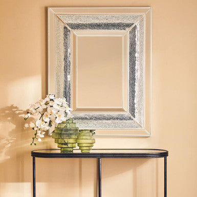 Stylish Orsina Glass Vase in green with flowers, complementing a decorative mirror on a console table