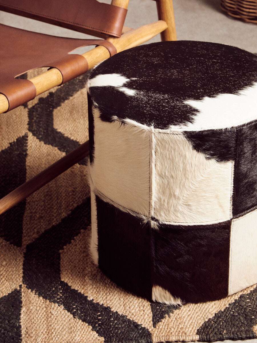 Orsina Hemp Rug with geometric patterns, paired with a stylish cowhide stool in a modern interior