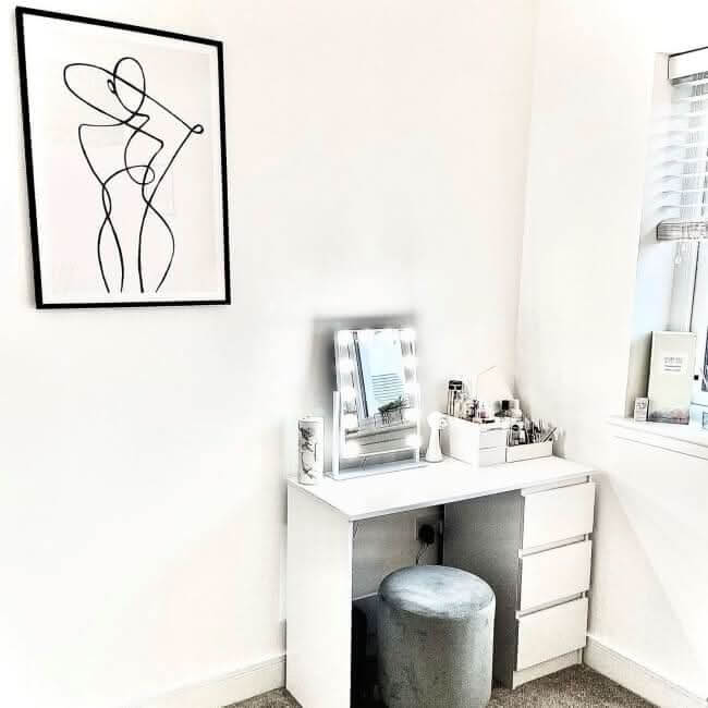 Stylish Hollywood Mirror on a modern vanity unit with beauty products in a bright room