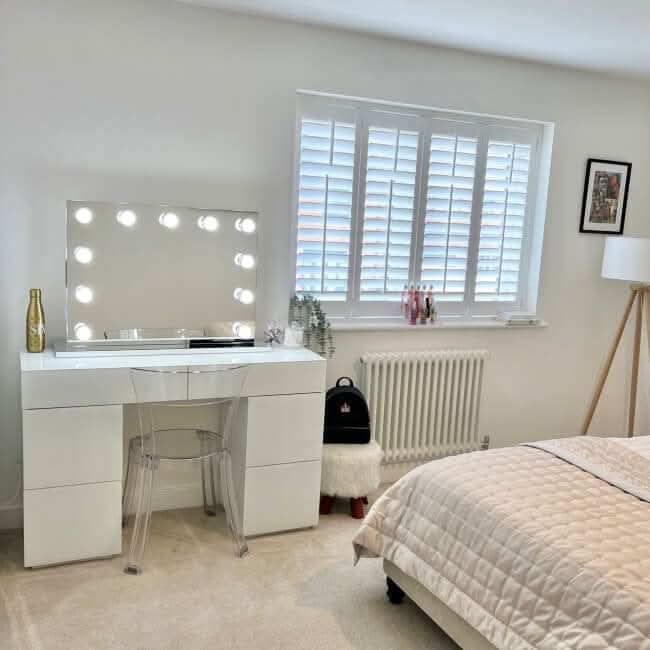 Stylish Hollywood Mirror with Bright Bulbs on Elegant Vanity Table in Modern Bedroom Setting