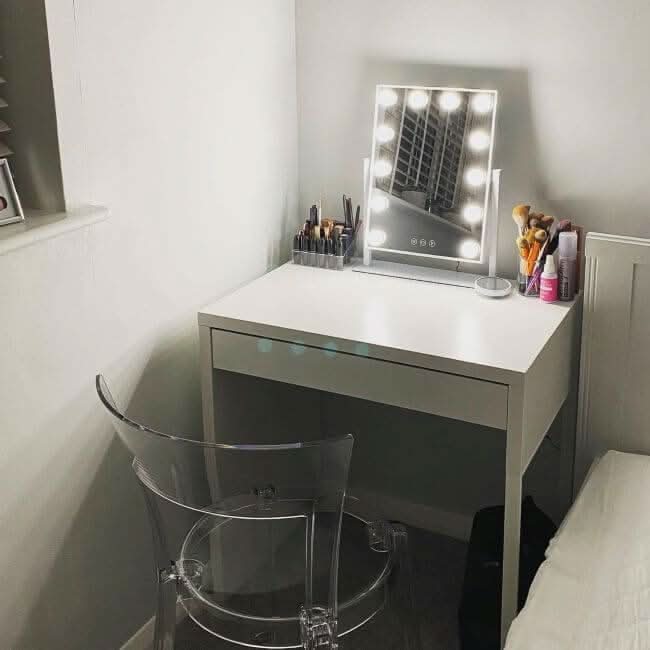 Elegant Hollywood Mirror on a white desk with makeup brushes and a clear chair in a stylish vanity setup