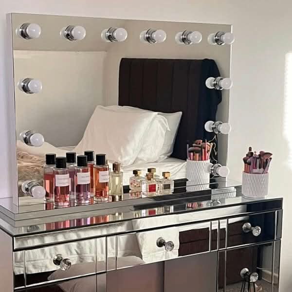 Hollywood Mirror with LED Lights Reflecting a Stylish Makeup Station and Fragrance Bottles