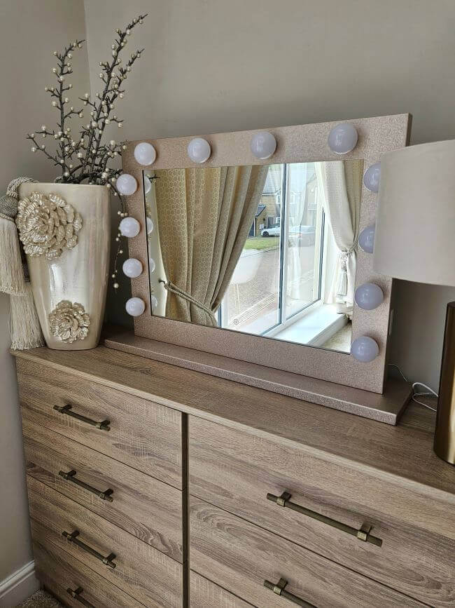 Hollywood Mirror with LED bulbs, stylishly placed on a wooden dresser in a bright room
