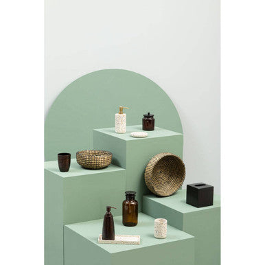 Stylish bathroom accessories display featuring an Orsina tumbler among various decor items
