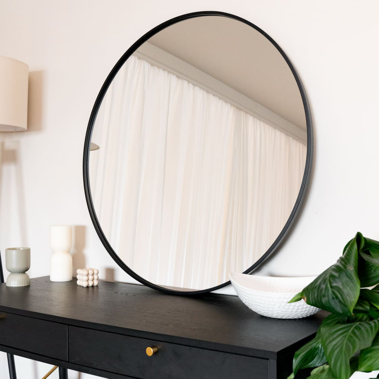 Jobu Home Circle Mirror with a sleek black frame above a stylish console table