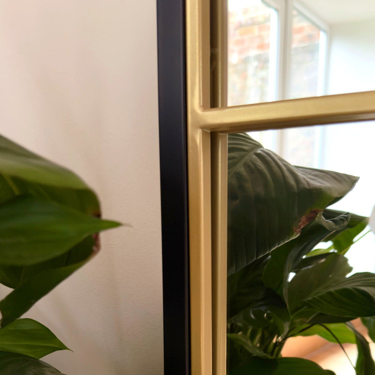 Elegant Grid Mirror by Jobu Home with a stylish frame, complementing indoor plants