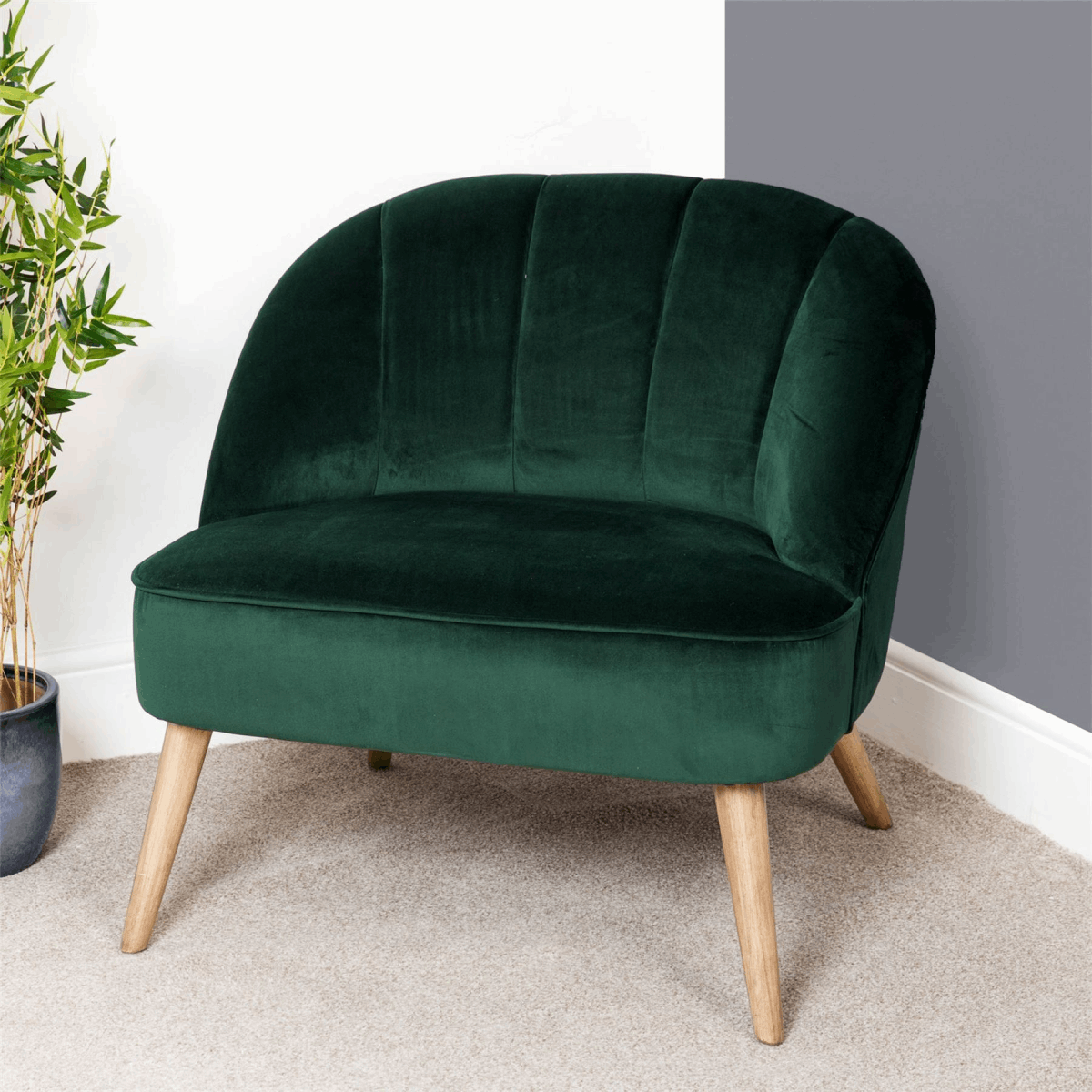 Green velvet luxury chair with curved back and wooden legs, perfect for stylish living spaces