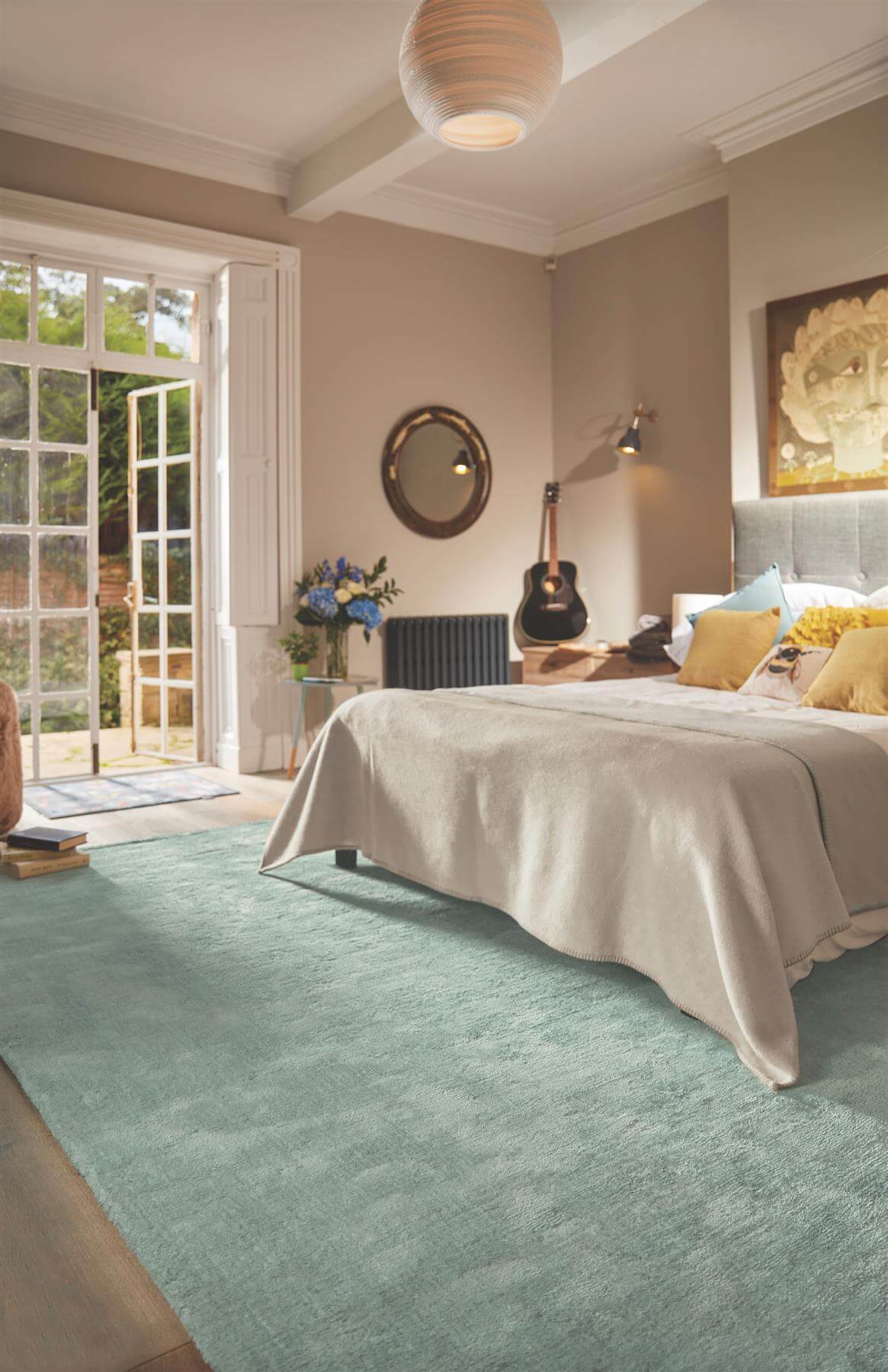 Elegant bedroom featuring a soft blue luxury rug under a bed with cushions and a serene atmosphere
