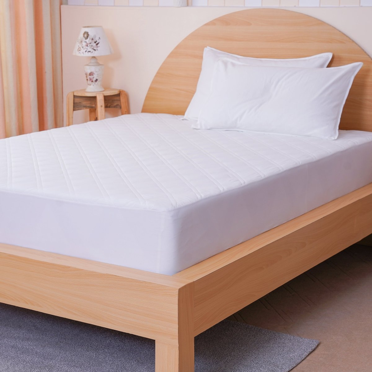 SHEET STORY Mattress Protector on a wooden bed frame, providing protection and comfort for a restful sleep
