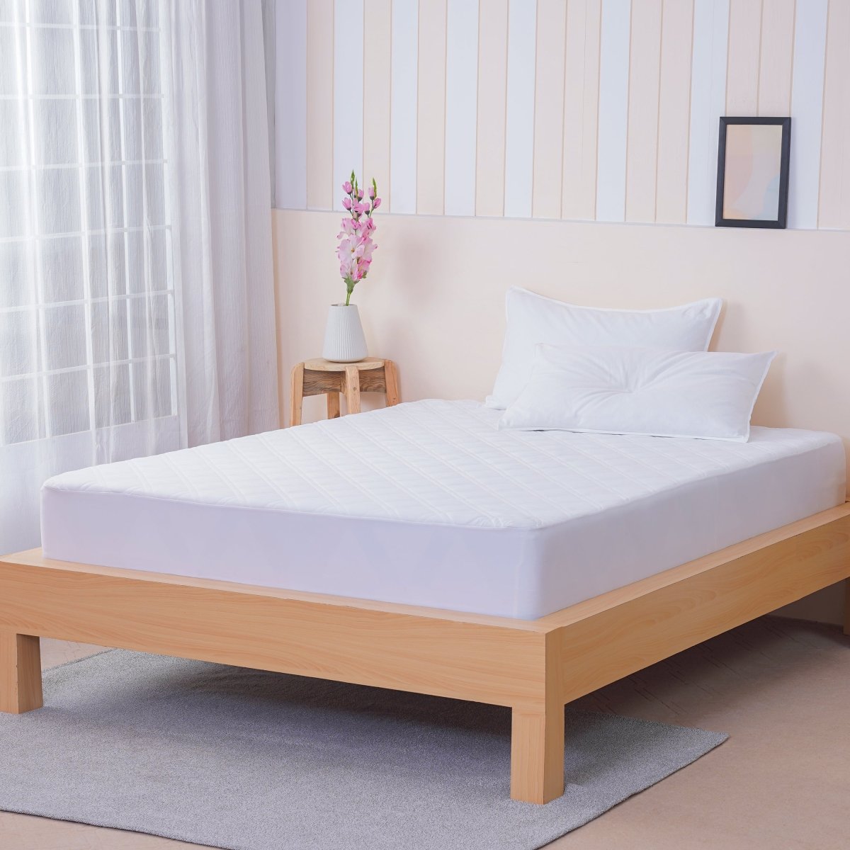 SHEET STORY Mattress Protector on a wooden bed with pillows, providing waterproof and breathable protection