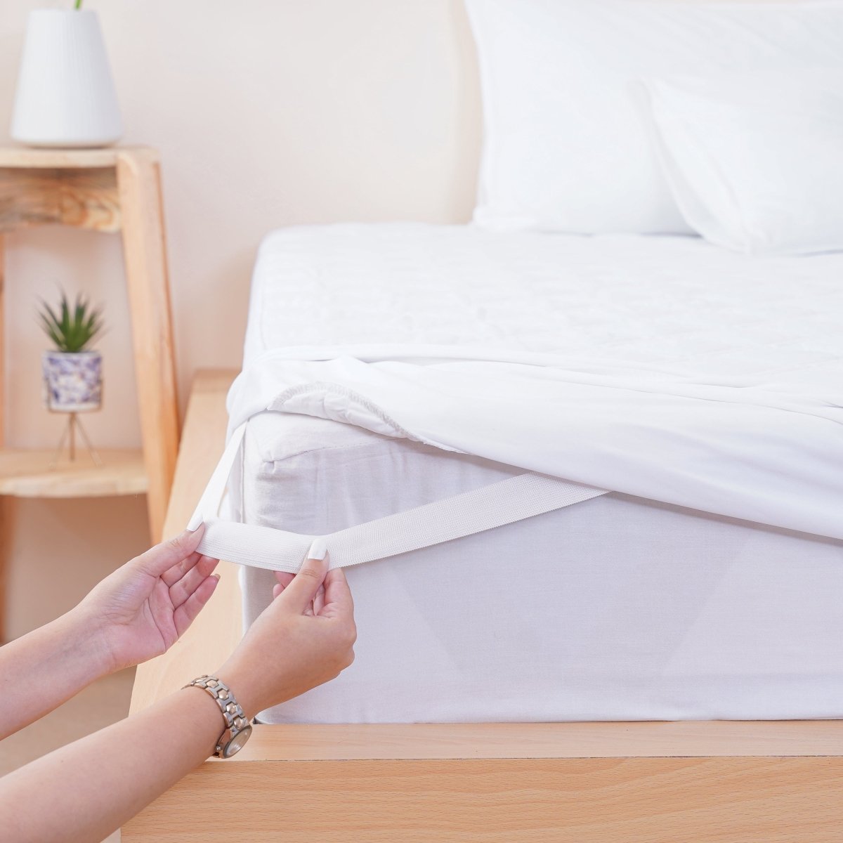 SHEET STORY Mattress Protector being secured on a mattress with elastic straps for a perfect fit