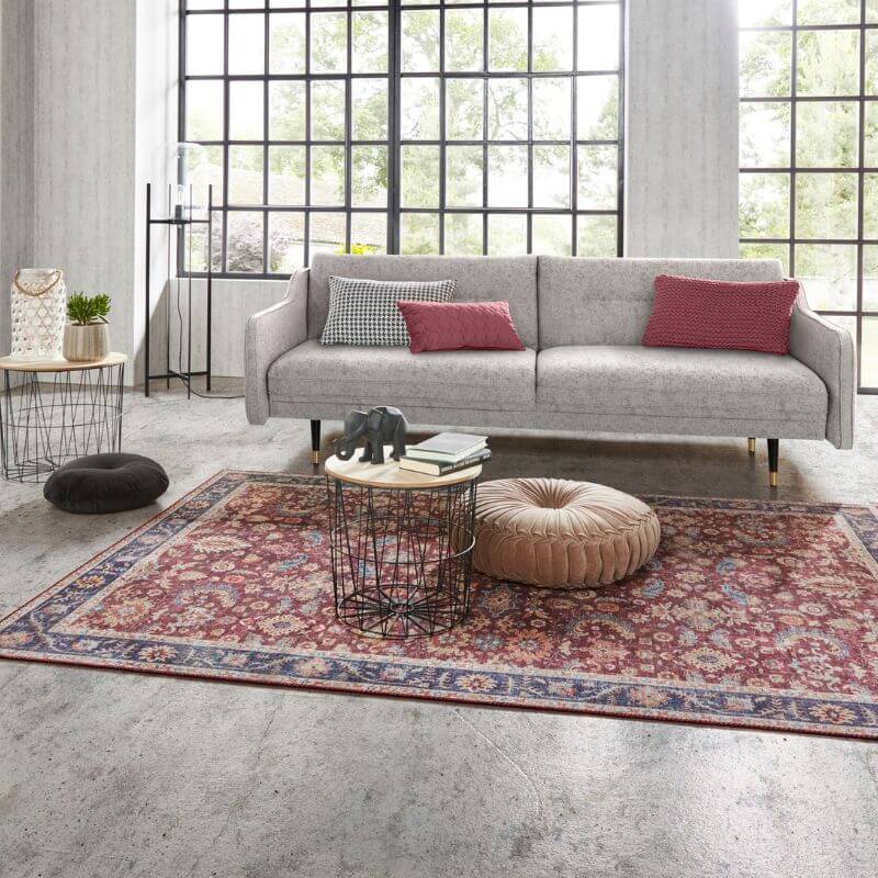 Medallion Rug in rich red tones, placed under a modern sofa in a spacious, bright living room