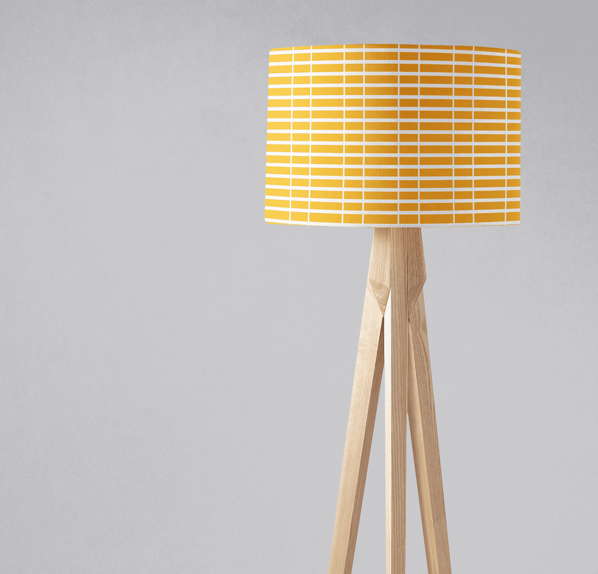 Bright yellow patterned lampshade from Shadow Bright on a wooden tripod base
