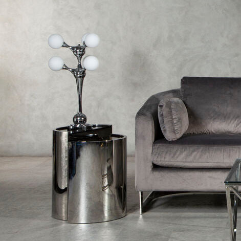 Orsina modern Table Lamp with four glass globes on stylish chrome base beside a grey sofa