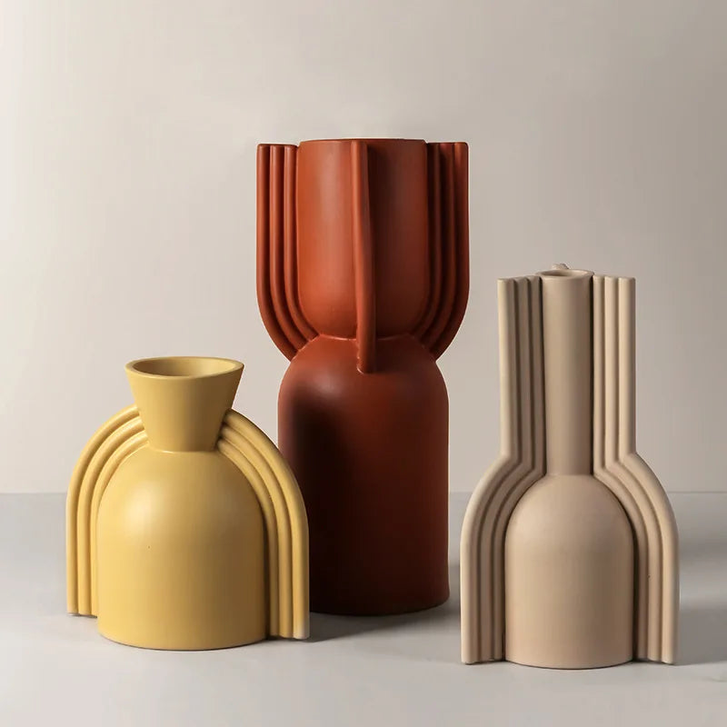 Set of three modern ceramic vases in yellow, terracotta, and beige with unique ribbed designs