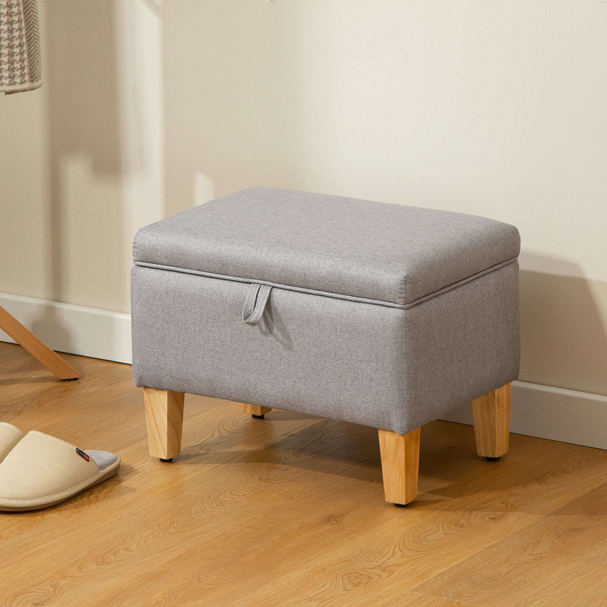 Grey padded footstool with wooden legs, ideal for added comfort and storage in any living space