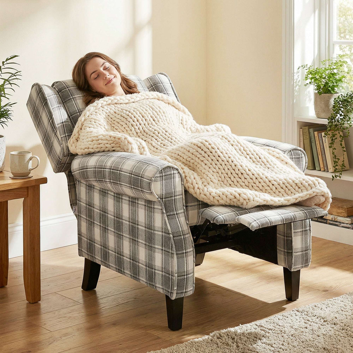Comfortable reclining armchair in plaid fabric with a woman relaxing under a chunky knit blanket