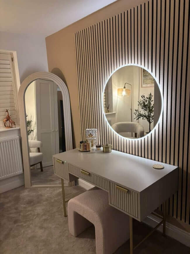 Stylish round mirror with built-in lighting above a modern vanity desk in a chic interior