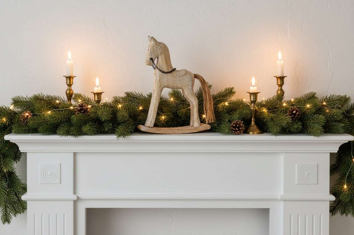 Rustic Rocking Horse decor atop a fireplace mantel adorned with greenery and candles for Christmas room decorations