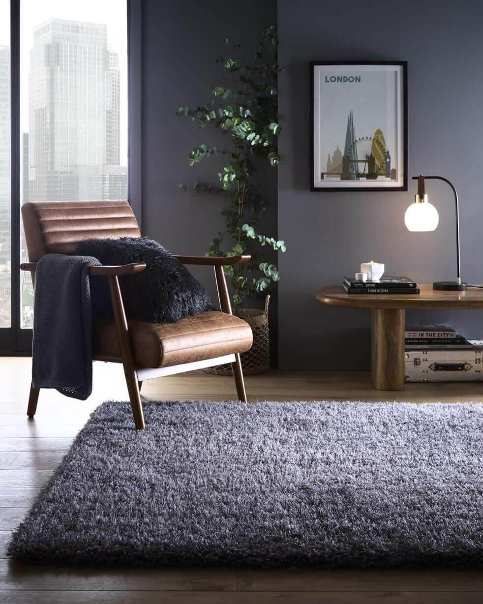 Stylish Shaggy Rug in Grey, enhancing a modern living room with a comfortable chair and contemporary decor.