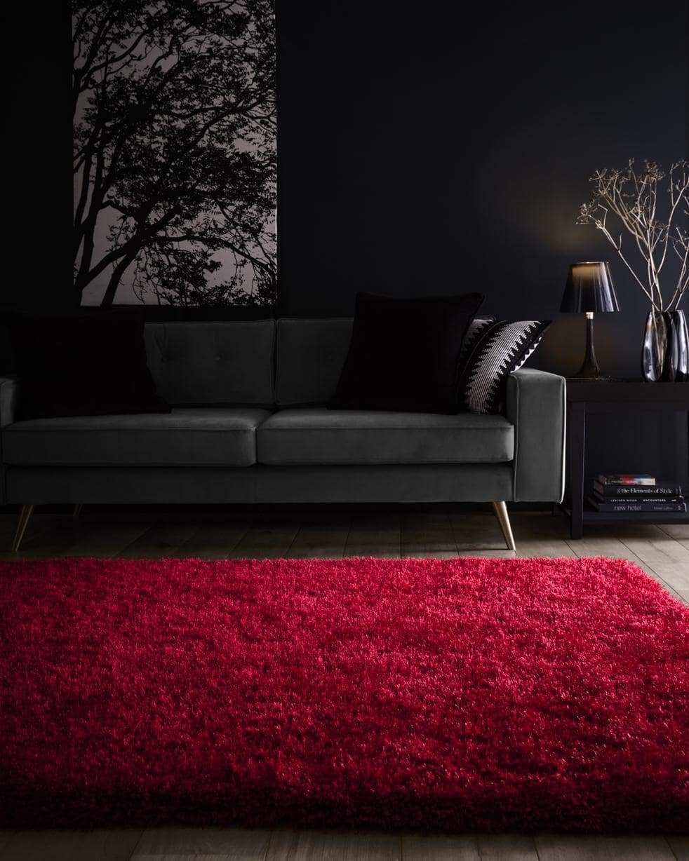 Vibrant red shaggy rug placed under a sofa in a stylish living room setting