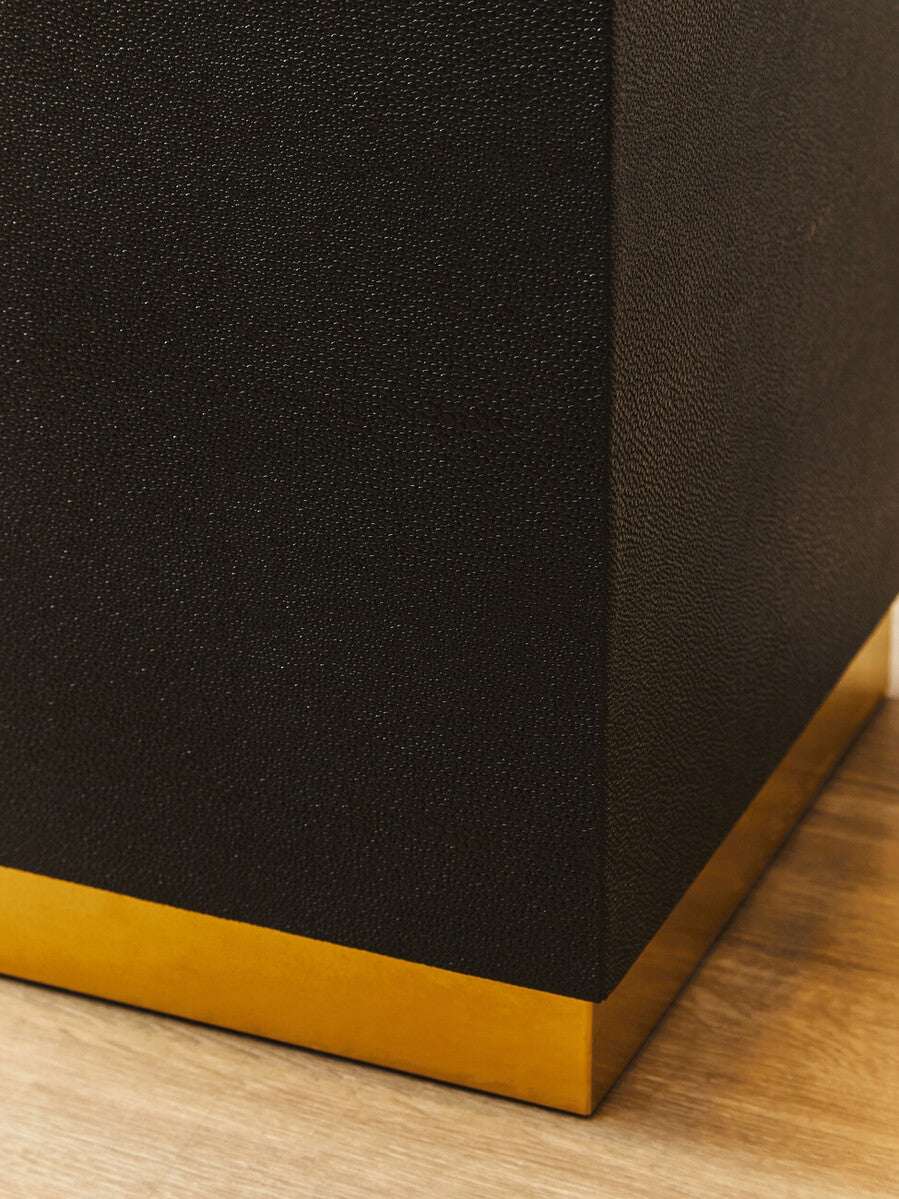 Close-up of Orsina Side Table featuring a textured black surface and a gold base accent